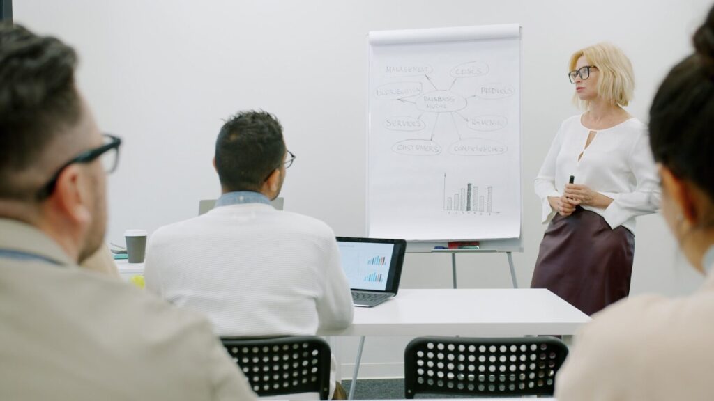 Woman presenting to audience in a modern office setting.